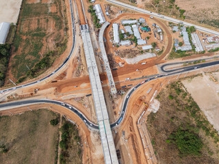 The construction site before the construction of the concrete bridge over the intersection by crane workers, tractors, and backhoes