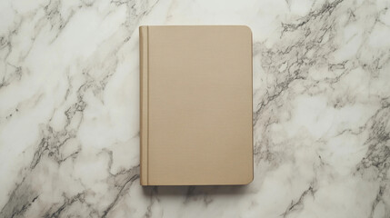 Closed vintage notebook with a beige leather cover on a marble surface. Ideal for journaling, writing, and classic stationery aesthetics.