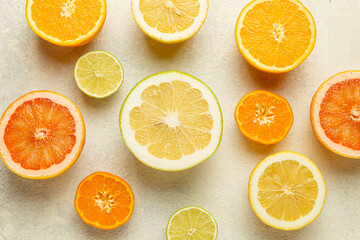 A close up of several oranges and limes on a white background. The oranges are sliced and the limes are whole. Concept of freshness and abundance