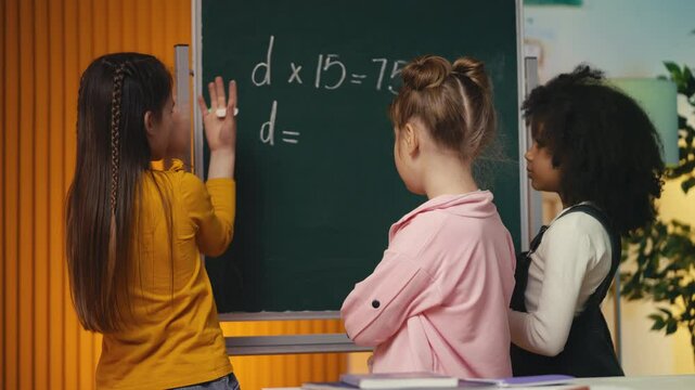 Three multiethnic classmates solving a math equation near the chalkboard, team
