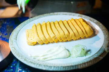 close-up Tamako Yaki cut into pieces, japanese rolled omelette or sweet egg.