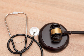 A gavel and stethoscope on wooden background, The law in medicine and medical negligence