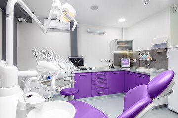 Modern Dental Clinic Interior with Purple Accents, Featuring Dental Chair, Equipment and Computer in a Clean and Bright Environment