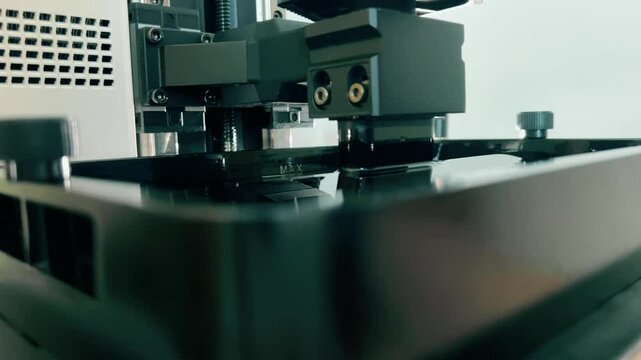 Descending build platform of a modern resin SLA 3D printer, close-up
