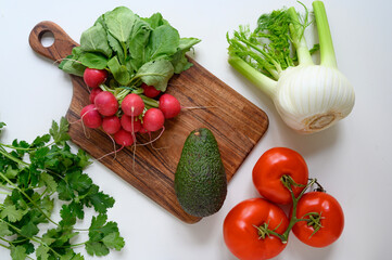 Preparing healthy food or a salad. Fresh vegetables and herbs on the table. 