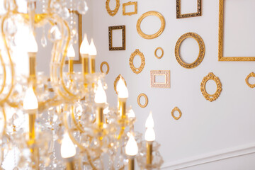 chandelier with many bulbs against the background of frames. passage to the second floor rich house