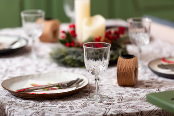 New Year's table setting in a photo studio. Plates with glasses on a Christmas tablecloth