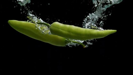 Green Peppers Falling into Water on Black Background in Slow Motion - Powered by Adobe