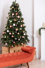 orange sofa next to white fireplace and christmas tree. bronze sofa on light background photo studio