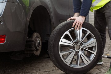 A man performs seasonal tire changes and prepares a car for winter or summer, demonstrating care in...