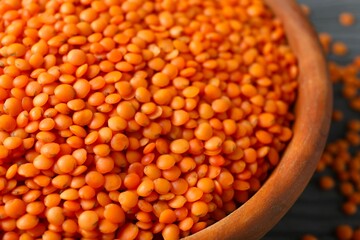 Red lentils in a bowl on wooden background 
