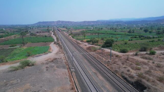 Aerial view of the saffron coloured Vande Bharat Express near Pune India. This train is between Pune and Kolhapur and also a tri-weekly train between Pune and Hubbali.