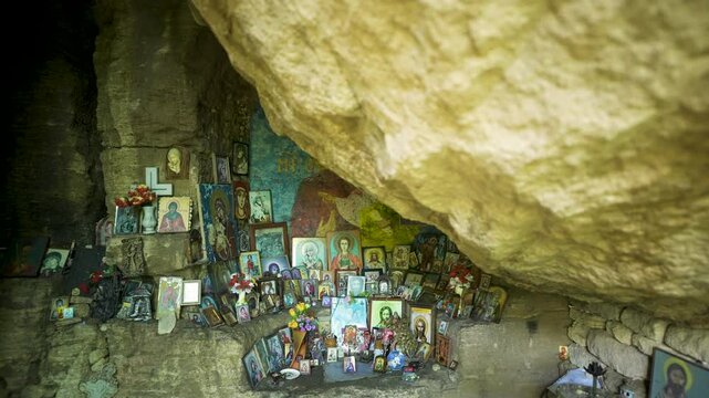 Pedestal shot moving from the top going down, showing the religious icons inside a sacred cave in the Madara Plateau in Bulgaria.