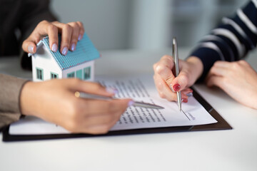 Real estate agent assisting clients with property contract signing.