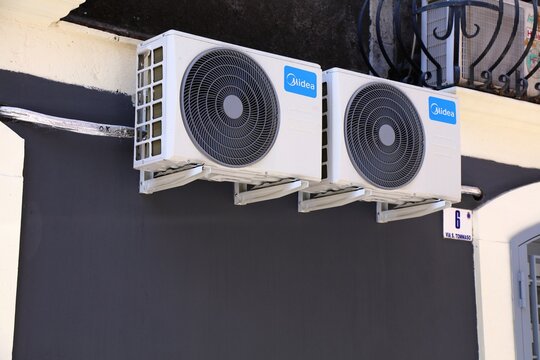 CATANIA, ITALY - AUGUST 7, 2024: Public street view of Midea brand wall mounted air conditioner unit in Catania city on Sicily island, Italy.