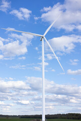 Wind farm on the cape. Wind turbine in a wheat field on a sunny summer day.
