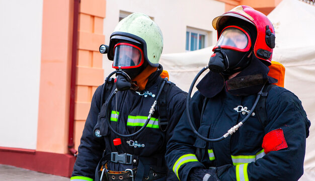 Firefighters in protective gear preparing for emergency response in urban area during daylight