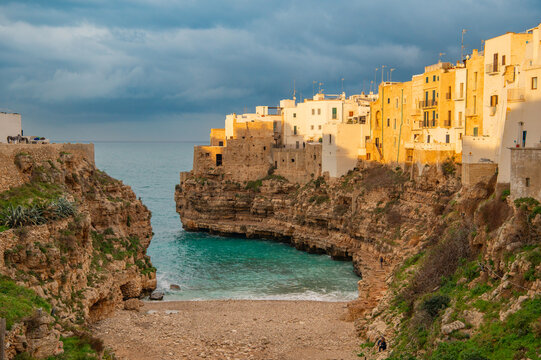 View of Lama Monachile Bay in Polignano a Mare at sunset, Puglia, Italy. Travel photography. Golden hour landscape.