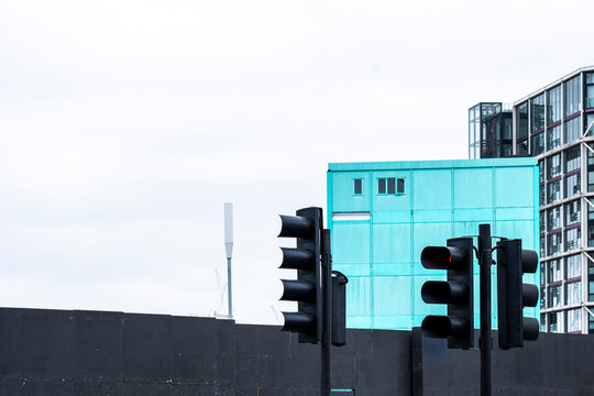 Traffic lights in a cityscape with a modern blue building in the background.
