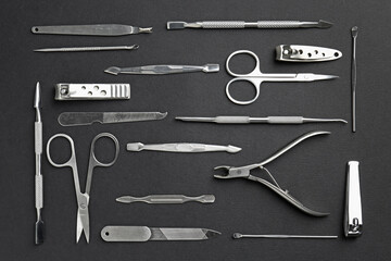 Set of pedicure tools on black background, flat lay