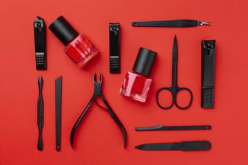 Set of pedicure tools on red background, flat lay
