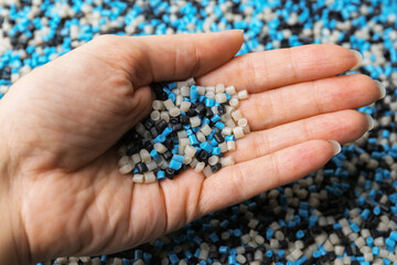 Woman with colorful plastic granules on blurred background, closeup