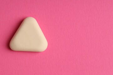 One eraser on pink background, top view. Space for text