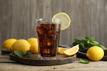 Fresh iced cola with mint and lemons on wooden table