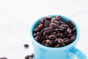 コーヒーを飲むマグカップと、焙煎したコーヒー豆
