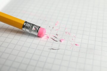 Using pencil with eraser on white sheet of paper, closeup