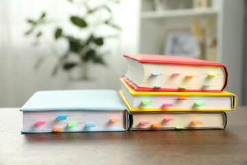 Books with colorful tabs on wooden table indoors