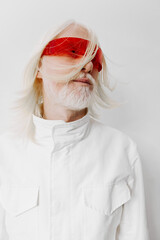 Fashionable model with unique red sunglasses, white shirt, and long hair, showcasing an avant garde...