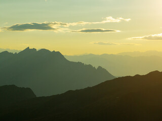 Breathtaking mountain scenery, Dolomites glowing warm sunlight. Peaks rise aerial view, casting dramatic shadows. Atmosphere makes perfect for travel, outdoor adventures, nature appreciation, getaways
