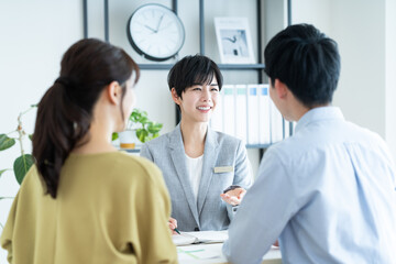 若い夫婦に営業するビジネスウーマン