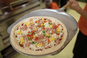a professional chef assembles and cooks a delicious pizza.