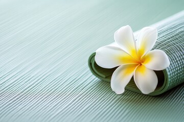 Plumeria flower on a teal yoga mat