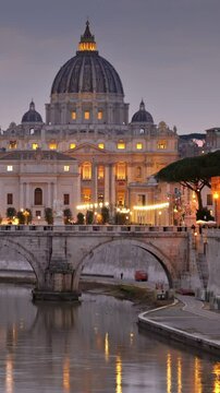 Stunning view of Vatican City at twilight showcasing St. Peter's Basilica and the illuminated bridge. Rome, Italy. Vertical shot