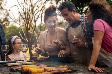 Happy family and friends enjoying outdoor barbecue gathering