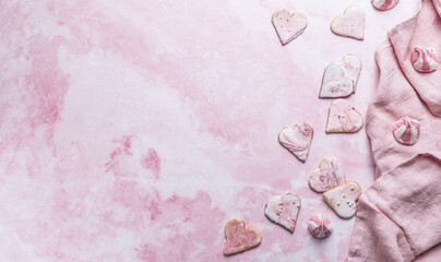 Homemade decorated heart shaped cookies on pink background