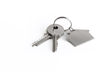 The house keychain and keys are highlighted on a white background. The concept of real estate transactions.