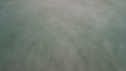 Aerial drone shot panning up from ice to show a lake and a bridge dam. - Powered by Adobe