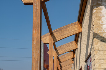 glulam with signs of wear due to time and weather. structure with arched beams and supporting pillars. commercial building designed with structural exposed modules. project, glued laminated timber