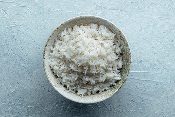White rice, cooked. A bowl of boiled long grain rice, a simple side dish, overhead flat lay shot