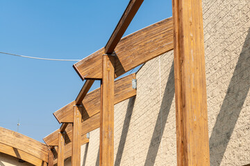 glulam with signs of wear due to time and weather. structure with arched beams and supporting pillars. commercial building designed with structural exposed modules. project, glued laminated timber