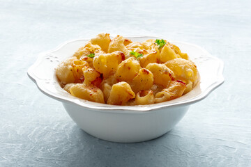 Mac and cheese, the classic pasta with macaroni and Cheddar cheese, garnished with parsley