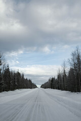 Obraz premium Snow covered road in North Finland on a sunny winter day. Travel Finland landscape background.