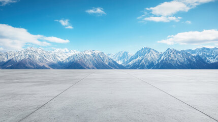 wide, empty concrete floor with stunning mountain backdrop under clear blue sky creates serene and expansive atmosphere