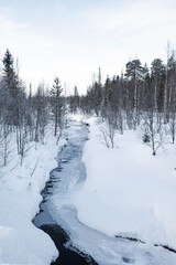 Snow covered river in North Finland on a cloudy day.