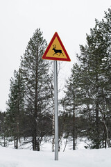 Reindeer warning sign at the side of a road in Finland in winter.