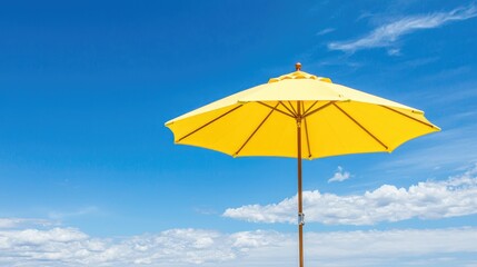 Fototapeta premium Yellow beach umbrella under blue sky, summer vacation
